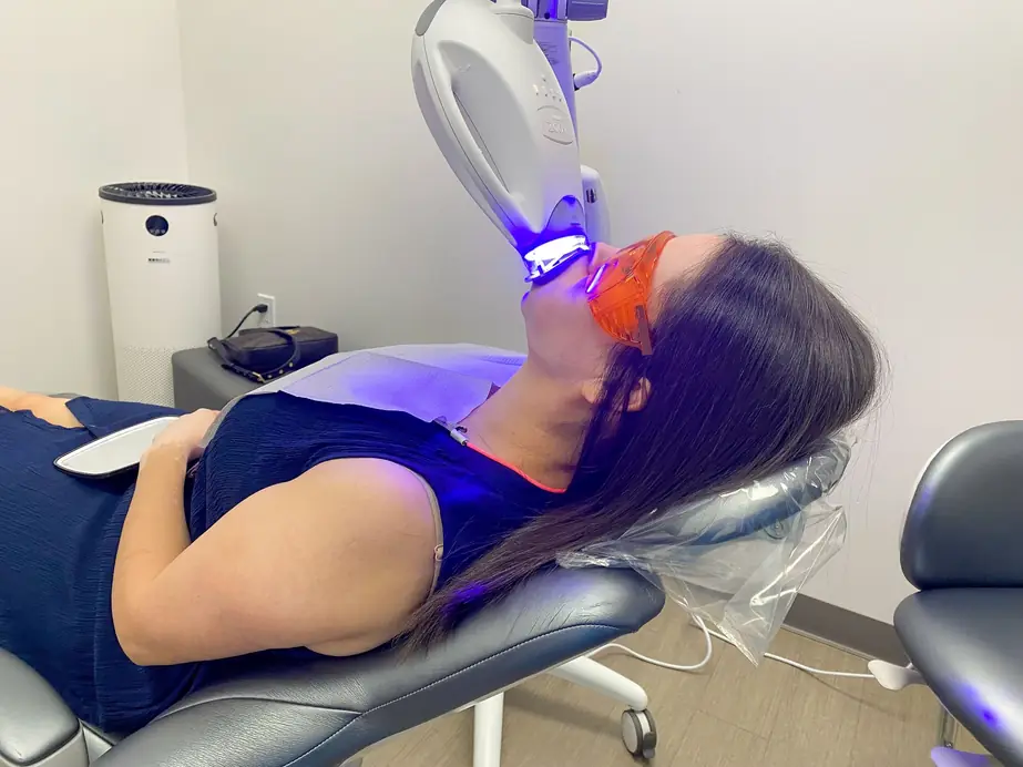 Philips Zoom whitening light over a patient wearing orange protective goggles